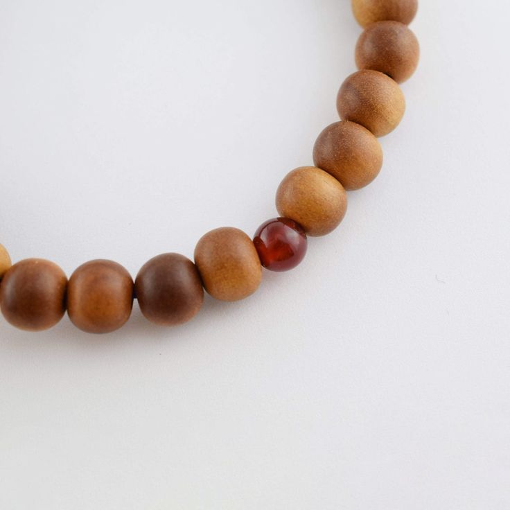 8mm Indian sandalwood Beads Bracelet Material : Indian sandalwood, Red Agate, Silk elastic cord Length : about 17cm Main beads : about 8mm Head bead : about 10mm Handmade in Kyoto, JAPAN Sandalwood is the second-most expensive wood in the world, the wood and the oil produce a distinctive fragrance that has been highly valued for centuries. Sandalwood oil has a distinctive soft, warm, smooth, creamy, and milky precious-wood scent. Sandalwood is mentioned in various suttas of the Pāli Canon. In some Buddhist traditions, sandalwood is considered to be of the padma (lotus) group and attributed to Amitabha Buddha. Sandalwood scent is believed by some to transform one's desires and maintain a person's alertness while in meditation. It is also one of the most popular scents used when offering inc Spiritual Wooden Beaded Bracelets, Spiritual Brown Wooden Beaded Bracelets, Spiritual Natural Wood Beaded Bracelets, Spiritual Brown Beaded Bracelets With Wooden Beads, Spiritual Brown Rosary Bracelet With Beads, Spiritual Brown Rosary Bracelet For Meditation, Spiritual Brown Rosary Bracelet With Wooden Beads, Brown Rosary Bracelet With 8mm Beads For Meditation, Traditional Wooden Bracelet With Round Beads