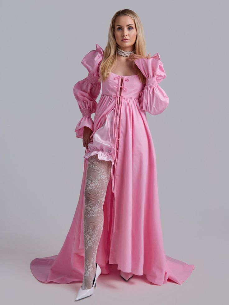 This dress is like stepping out of the pages of a Jane Austen novel. Its delicate pink hue, reminiscent of the blush of a woman who fell in love, captures the grace of Regency-era fashion. The fabric flows gently, evoking the timeless charm of old English gardens, making you feel part of a romantic and enchanting world. A-line maxi train dress with in casual glamour style. By untying the ties of the dress, it can easily be turned into a shawl and worn as a top layer over everyday clothes. The dr Pink Maxi Dress With Ruffled Fitted Bodice, Pink Maxi Dress With Ruffles And Fitted Bodice, Marie Antoinette Style Pink Wedding Dress, Pink Rococo Dress With Ruffles, Pink Victorian Dress With Ruffles And Long Sleeves, Pink Victorian Dress With Ruffles In Marie Antoinette Style, Elegant Pink Victorian Dress For Spring, Elegant Pink Victorian Spring Dress, Elegant Pink Victorian Dress With Long Sleeves