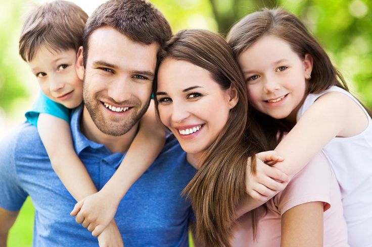 a family posing for a photo in the park