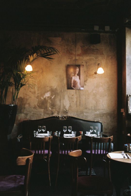 a dimly lit restaurant with tables and chairs