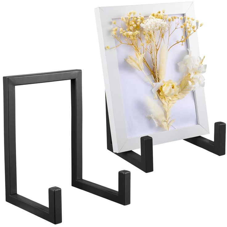 two black and white frames with flowers in them