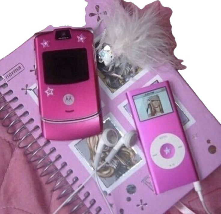 a pink cell phone sitting on top of a table next to other items and gadgets