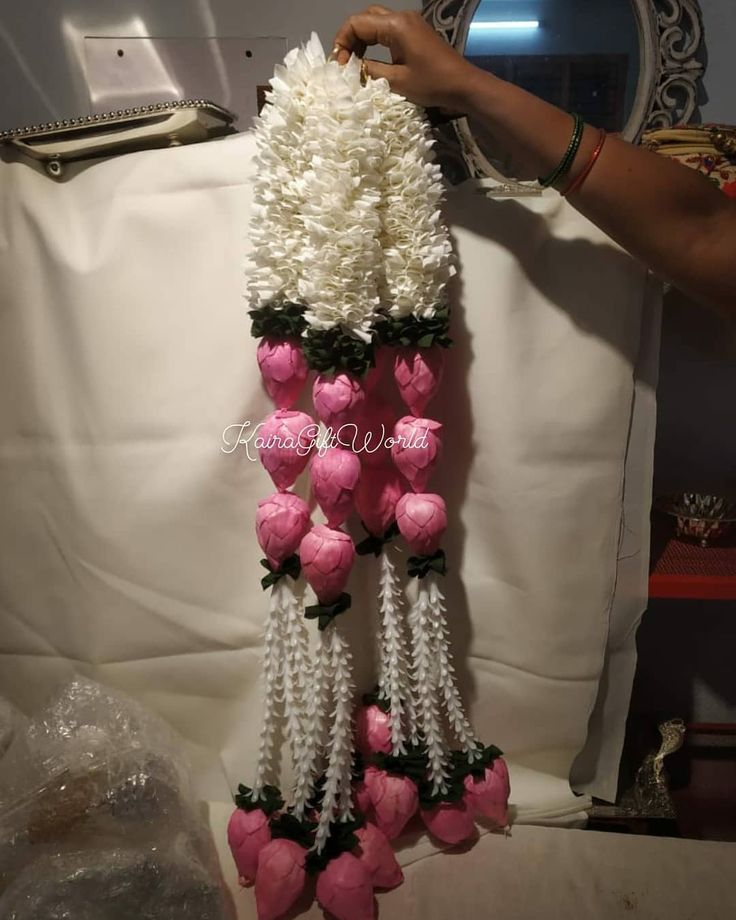 pink and white flowers are hanging from the back of a chair