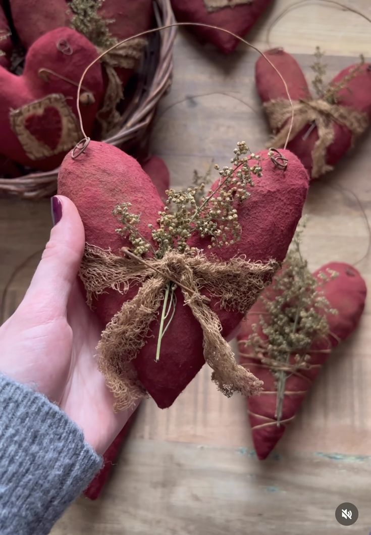 someone is holding up some red hearts