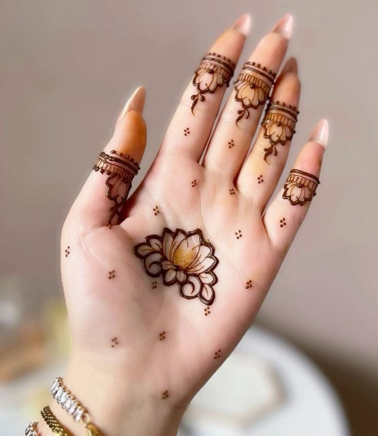 a woman's hand with henna tattoos on it