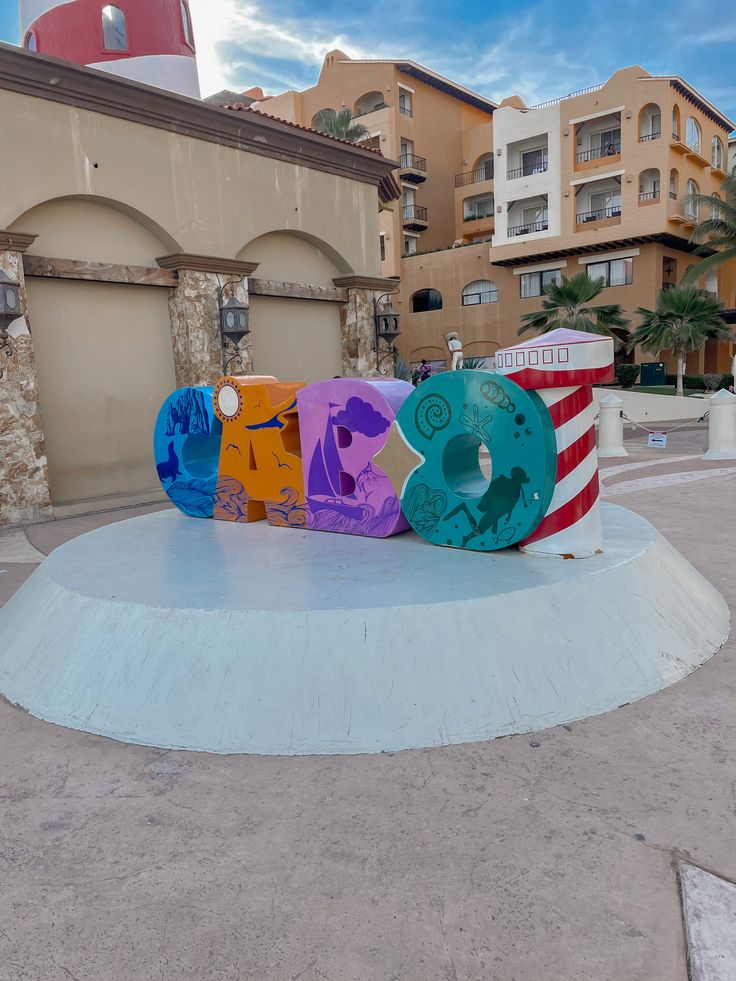 a skateboard that is sitting in the middle of a circular area with buildings behind it