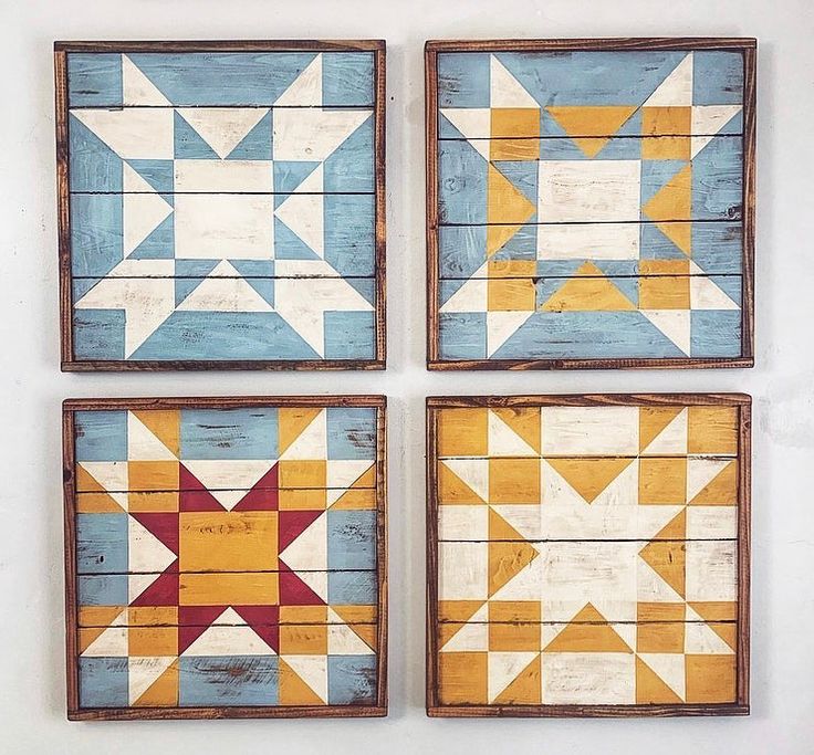 three wooden wall hangings with star designs painted on the sides, one in blue and yellow