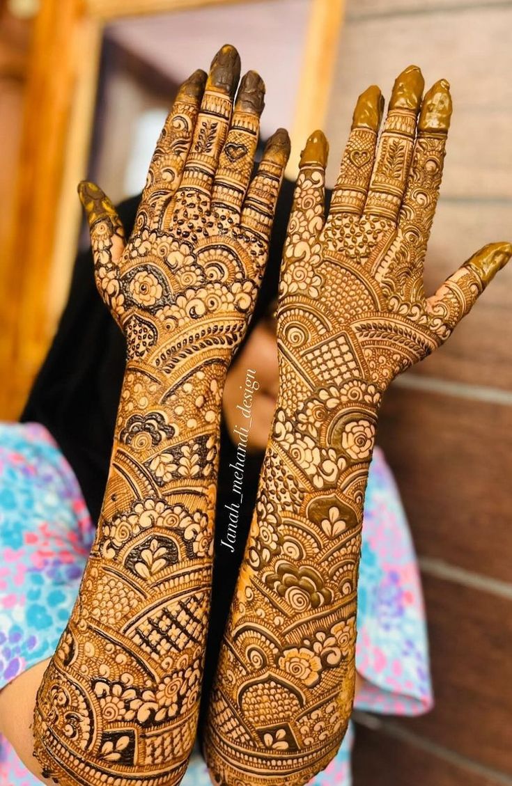 a woman's hands with hennap on her hand and the bottom half of her arm