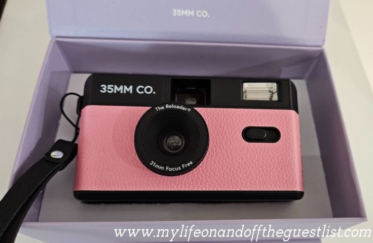 a pink and black camera in a purple box