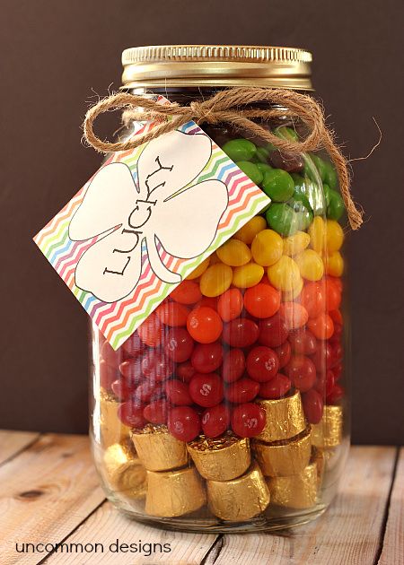 a jar filled with lots of candy and candies on top of a wooden table