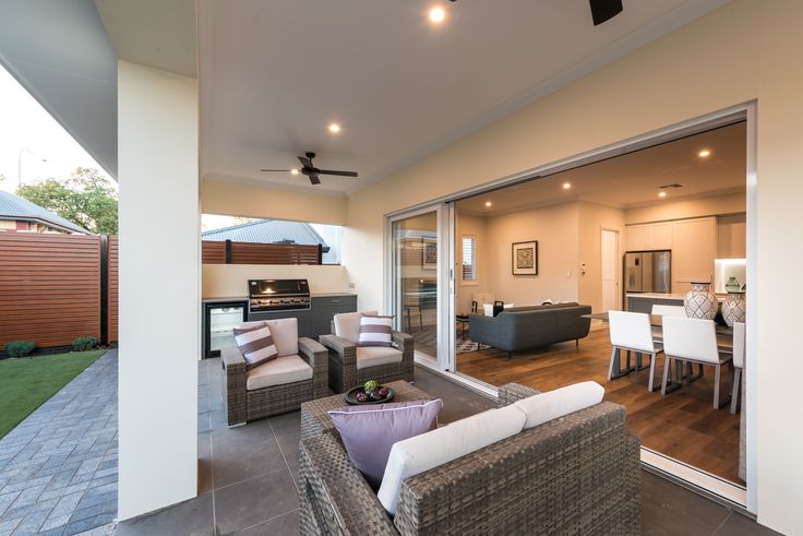 an outdoor living room and dining area with sliding glass doors