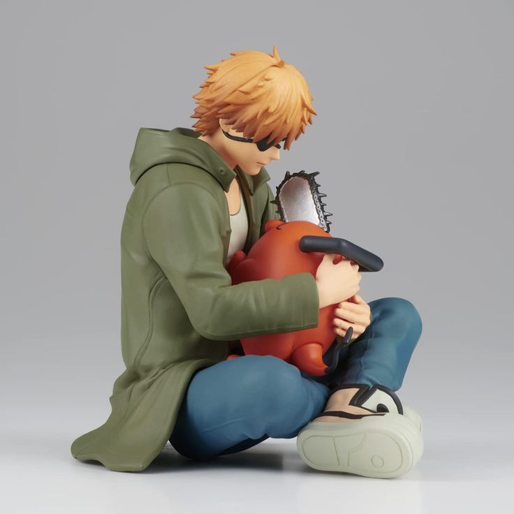 an anime figurine is sitting on the ground with another figure in front of him