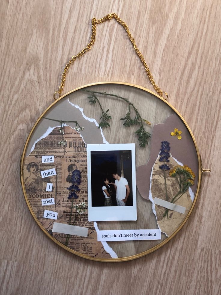 a round frame with pictures and words on it hanging from a wooden wall next to a gold chain