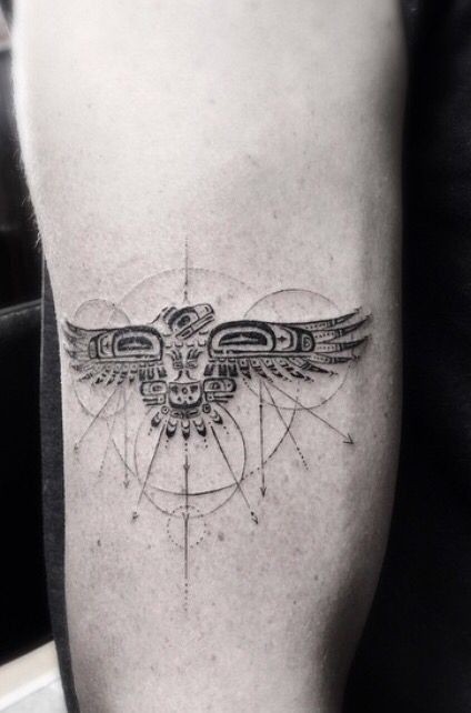 a black and white photo of a bird tattoo on the right leg, with circles around it