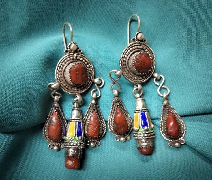 Magnificent kabyle earrings in sterling silver enamelled with blue, green and yellow color, inlaid with two cabochon of real coral. **Height: 7.6 cm. **Width: 3.7 cm. **Material: sterling silver 925, real coral. **Weight: 35.4 grams. **Origin: great Kabyle region 1970s - Algeria. **Shipping: free worldwide by DHL. I am always open to offers for one of my items, so please contact me if you would like to make an offer. Do not hesitate to contact me for any questions. All items advertised for sale Ceremonial Enamel Pendant Jewelry, Enamel Dangle Jewelry With Matching Earrings, Enamel Dangle Earrings With Matching Jewelry, Artisan Red Jewelry With Inlay, Ceremonial Sterling Silver Drop Earrings, Artisan Red Inlay Jewelry, Artisan Pierced Pendant Jewelry, Pierced Dangle Earrings In Enamel, Red Sterling Silver Jewelry For Festivals