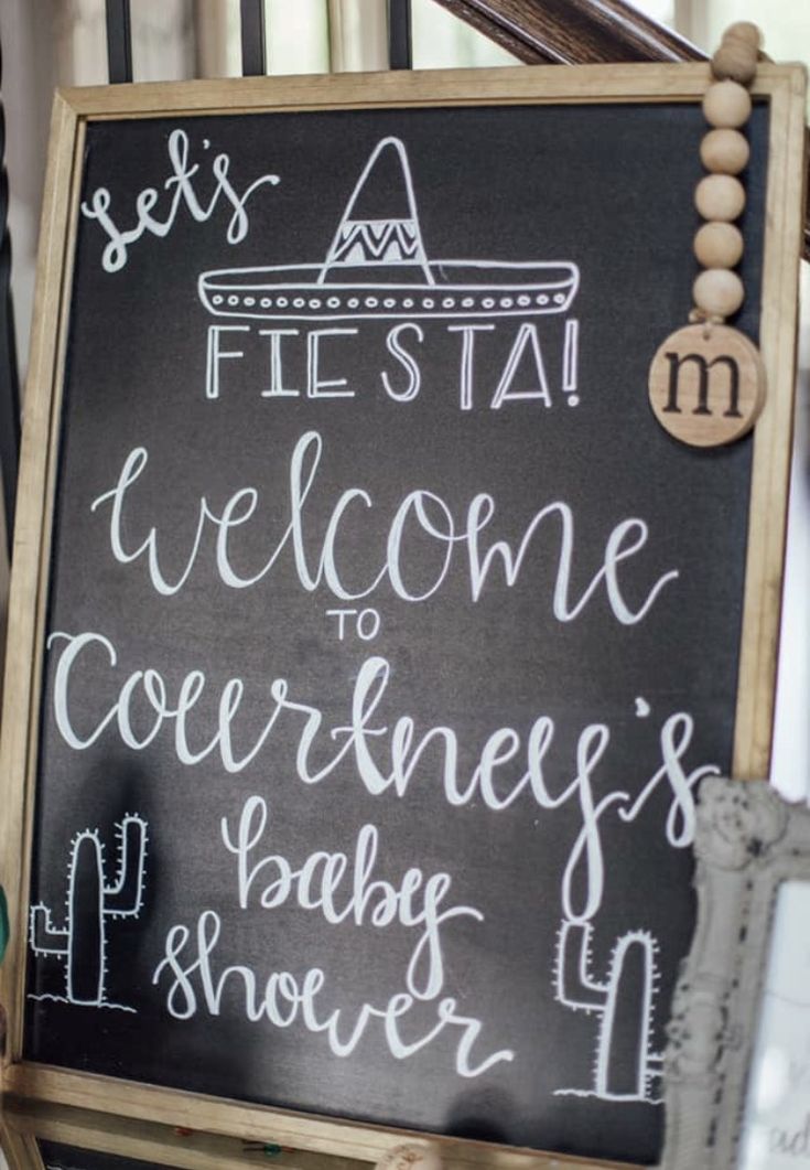 a chalkboard sign that says fiesta welcome to correnes baby's shower