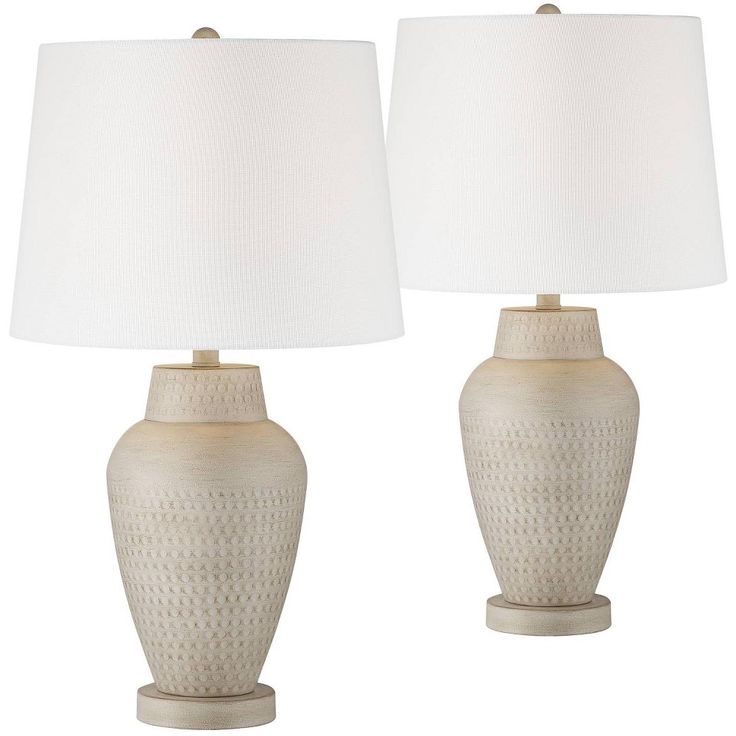 two white ceramic lamps with shades on them