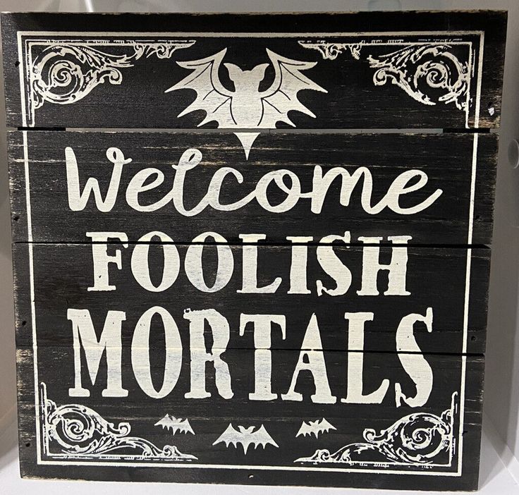 a black and white sign that says welcome foolish mortals on the front side