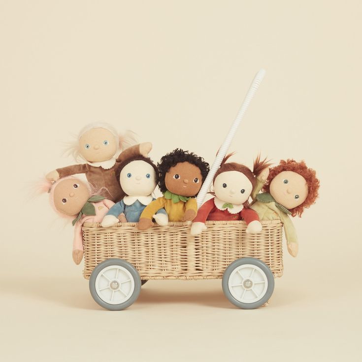 a group of stuffed animals sitting in a wagon with wheels on a beige background,