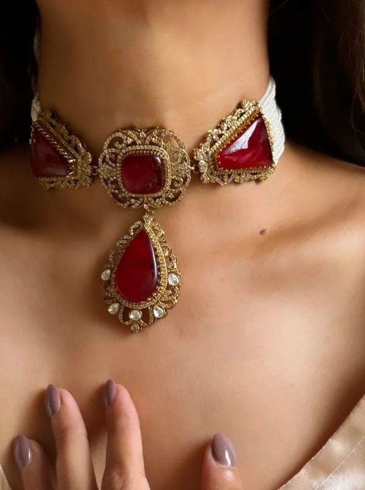 Discover the timeless elegance of the Red Victorian Gold Sabyasachi-inspired uncut polki Kundan choker necklace. This exquisite Indian bridal jewelry piece showcases a stunning blend of traditional craftsmanship and modern luxury. Adorned with uncut polki stones and intricate Kundan work, the necklace features a rich red and gold palette, capturing the opulence and grandeur reminiscent of Bollywood glamour. Perfect for brides seeking to make a regal statement, this choker combines classic Victor Luxury Red Bollywood Earrings, Luxury Kundan Bridal Earrings With Intricate Design, Luxury Elegant Kundan Necklace, Luxury Diwali Choker With Intricate Design, Luxury Gold Kundan Necklace Statement Piece, Luxury Red Kundan Necklace For Festivals, Luxury Red Kundan Jhumkas, Luxury Red Kundan Temple Necklace, Luxury Red Kundan Bridal Earrings