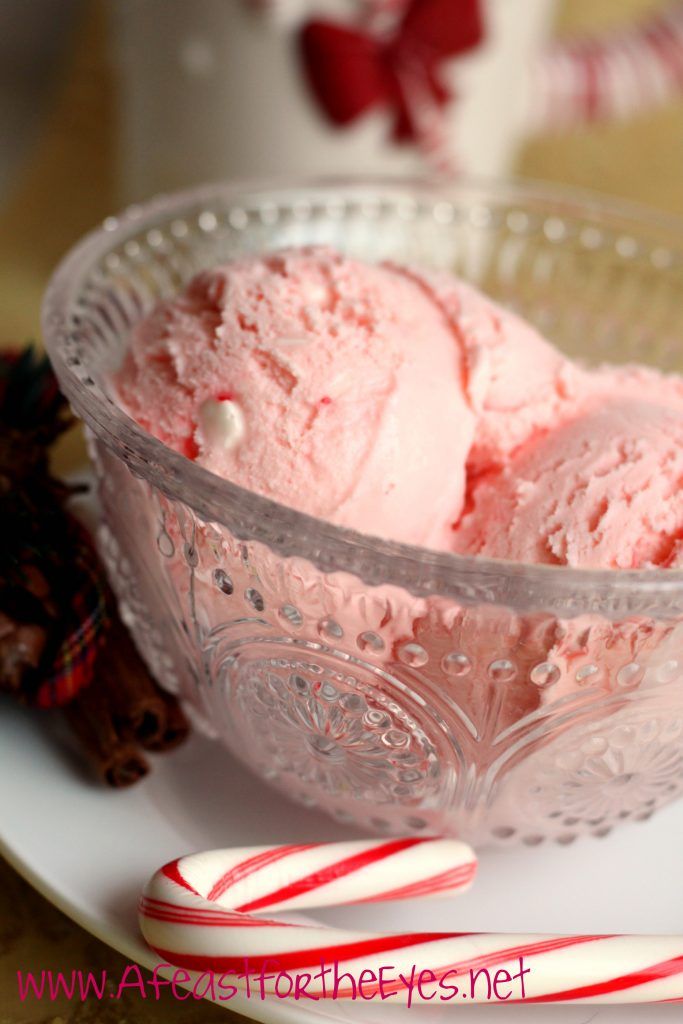 two scoops of ice cream sit in a glass bowl next to candy canes