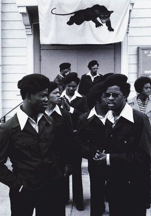 a group of young men standing next to each other in front of a white building