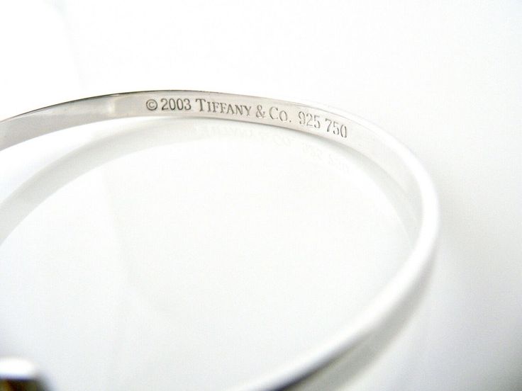 Overview: Offered for sale is a wonderful and gorgeous Tiffany & Co. Sterling Silver 18K Gold Heart Hook Bangle. Definitely a Tiffany piece that you will get your money's value for. It works perfectly with pretty much any attire your put on, AND is a great statement piece. The piece looks fabulous worn alone, but is also a wonderful piece with which to start or add to your Tiffany collection. Very versatile indeed! This piece is simple, elegant, and classic all rolled into one bracelet. Imag Luxury Hallmarked Diamond Bracelet For Anniversary, Luxury Polished Bangle For Wedding, Designer Jubilee Bracelet Bangle For Anniversary, Luxury Anniversary Bangle With Polished Finish, Luxury Polished Wedding Bangle, Luxury Heart Bracelet As A Gift, Modern Wedding Diamond Bracelet With Polished Finish, Designer Polished Bangle For Wedding, Designer White Gold Round Bracelets