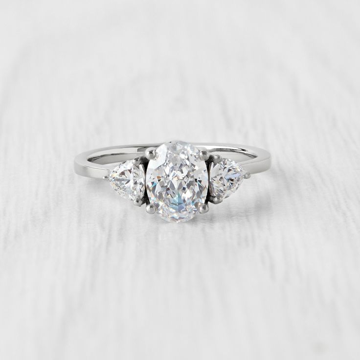 a three stone diamond ring on a white surface