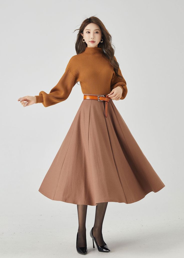 "Elevate your winter style with our brown wool swing midi skirt. The warm brown hue adds a touch of classic charm, and the premium wool fabric provides both style and warmth. The carefully crafted buttons create an elegant and dynamic look. This versatile midi skirt effortlessly transitions from day to night, making it a must-have choice for those who seek both fashion and coziness. DETAILS: * 30% wool, 30% fiber, 40% polyester * Fully satiny liner * Without pockets * Back zipper closure * Circl Wool Circle Skirt, Beige A-line Pleated Skirt For Fall, Winter Beige Flared Skirt, Beige Flared Skirt For Winter, Beige Long Winter Skirt, Beige Long Skirt For Winter, Beige A-line Skirt For Fall, Fall Beige A-line Skirt, Brown Flowy Skirt For Fall