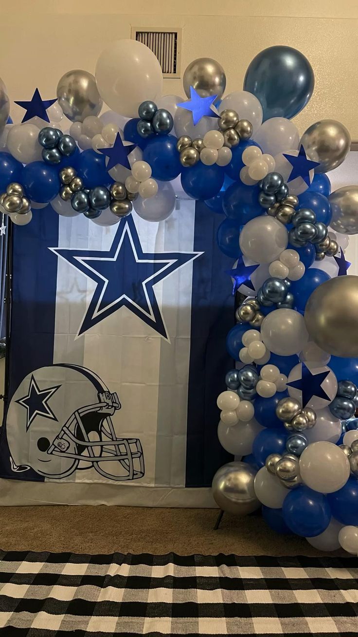 balloon arch with football helmet and stars on it in front of a wall decorated with balloons