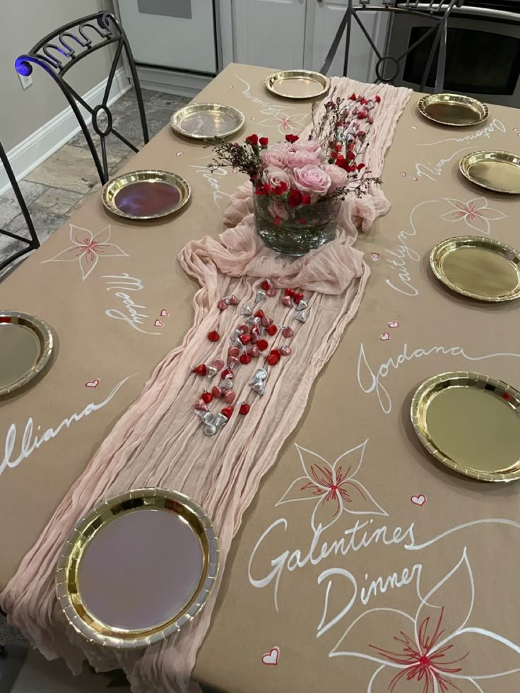 a table set up with plates and flowers in a vase on the top, along with other place settings