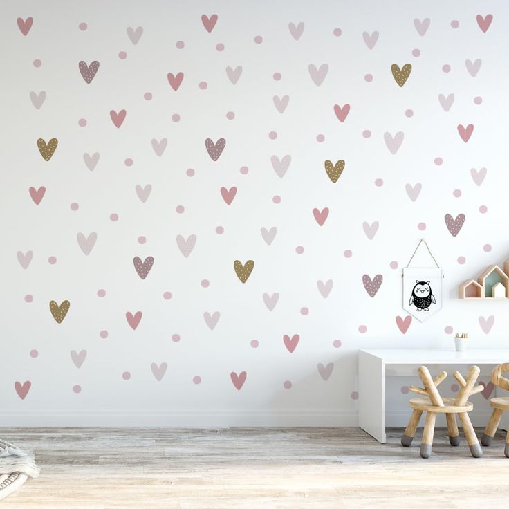 a child's room with pink and gold hearts on the wall