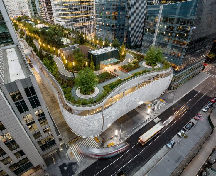 an aerial view of a city with tall buildings and lots of greenery on the roof