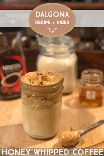 a jar filled with honey whipped coffee on top of a wooden table