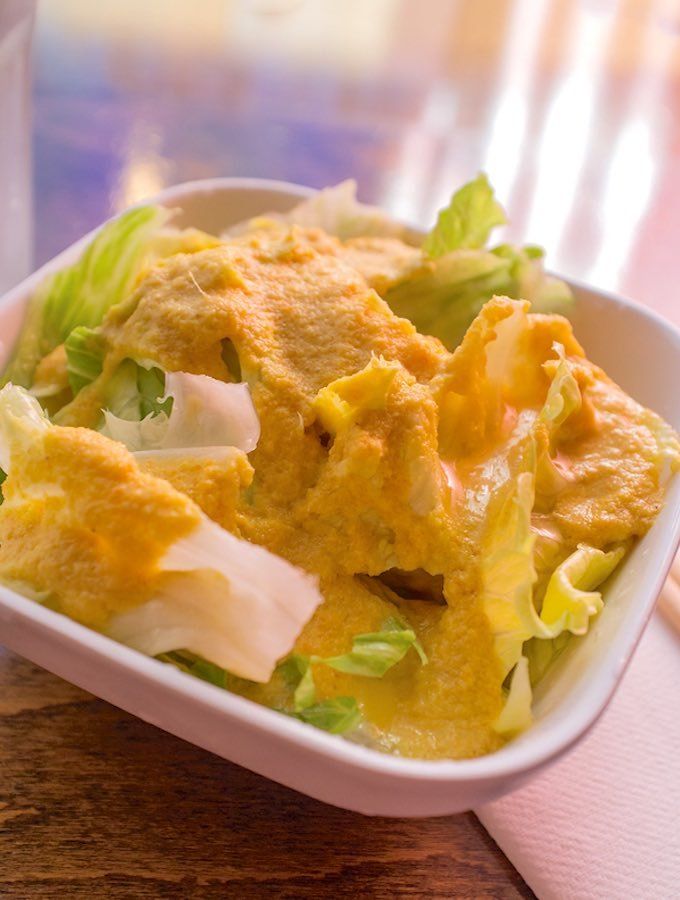 a white bowl filled with food on top of a wooden table