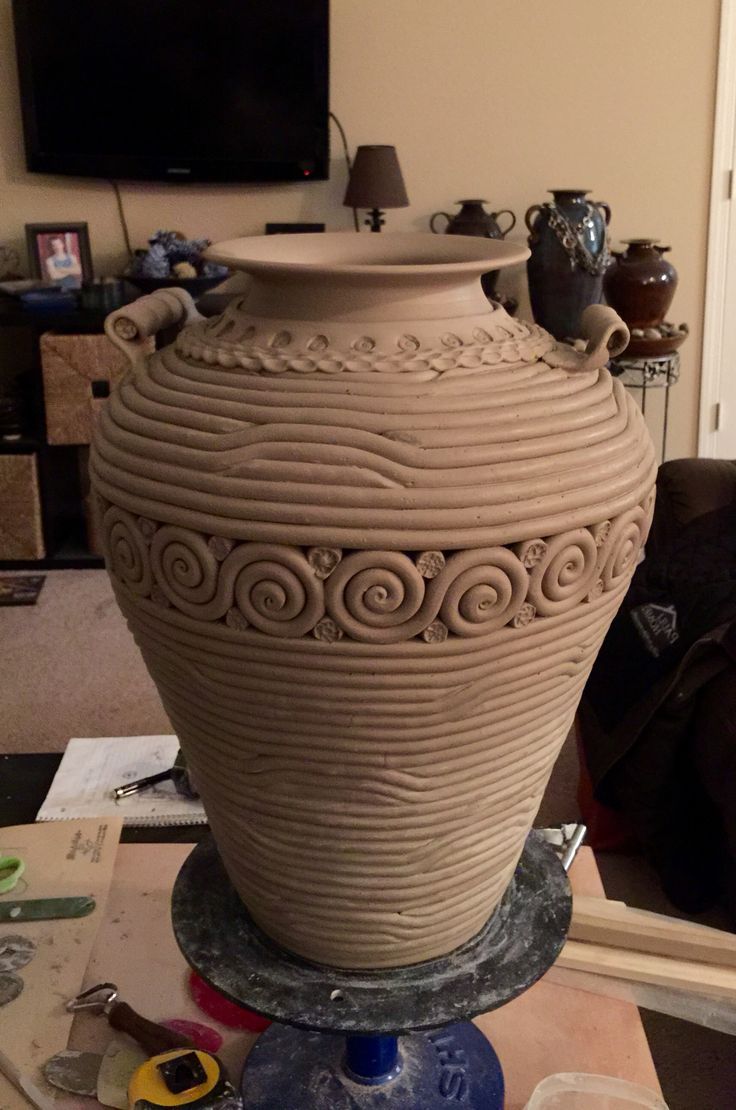 a large vase sitting on top of a table next to a tv set and other items