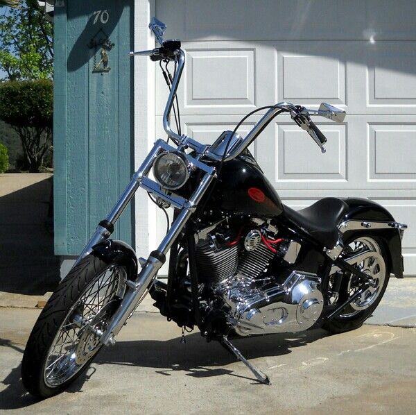 a black motorcycle parked in front of a garage