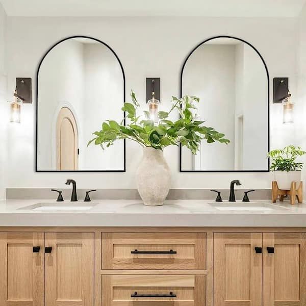 a bathroom with double sinks and mirrors in it's centerpiece, along with two planters on the counter