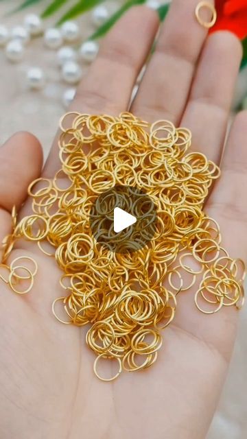 a person is holding some gold rings in their hand