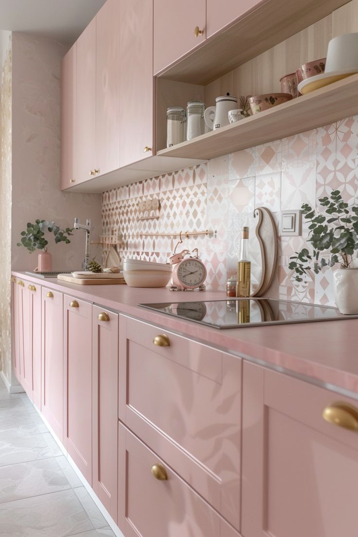 a kitchen with pink cabinets and gold pulls on the cupboards is seen in this image