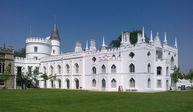 a large white castle sitting on top of a lush green field