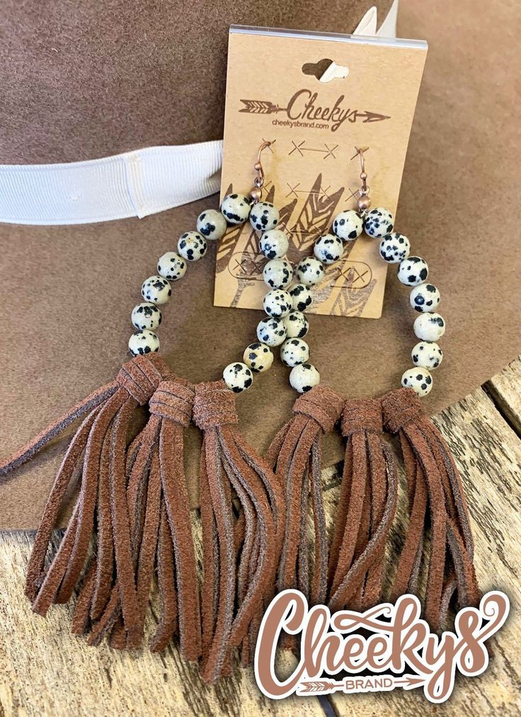 Cheekys Brand Original~ Willa Leather Tassel Earrings with Cow Print Beads and Brown Tassels These hook back earring will hang around 5 " in long with the tassels. They are a must have!All images & designs are copyrights & we have worked very hard to make them. Please feel free to use our images for social media & sharing, but please give credit when doing so.Always hypoallergenic, lead & nickel free! Limited to stock on hand.Thank you for shopping Cheekys!!! Cow Print Beaded Earrings, Western Crafts, Leather Jewelry Diy, Diy Leather Earrings, Beaded Earrings Tutorials, Tassel Jewelry, Beaded Earrings Patterns, Colorful Earrings, Beaded Hoop Earrings