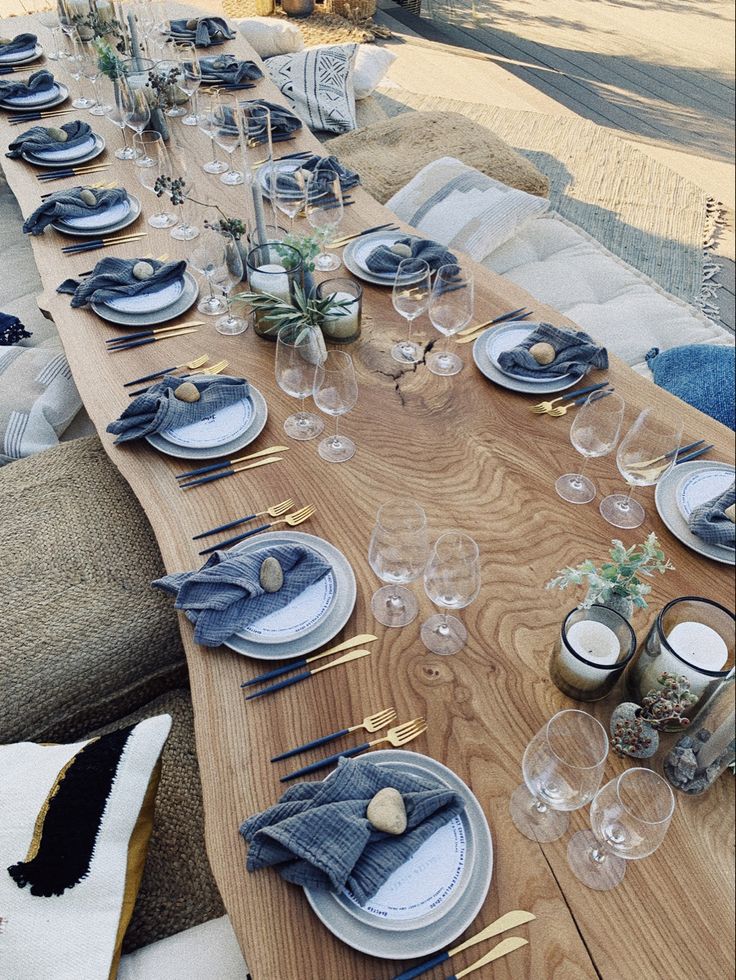 the table is set with blue and white plates, silverware, and napkins