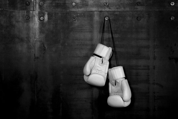 two white boxing gloves hanging on a wall