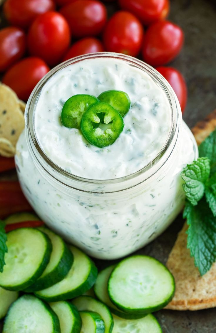 cucumber dip in a jar surrounded by fresh vegetables