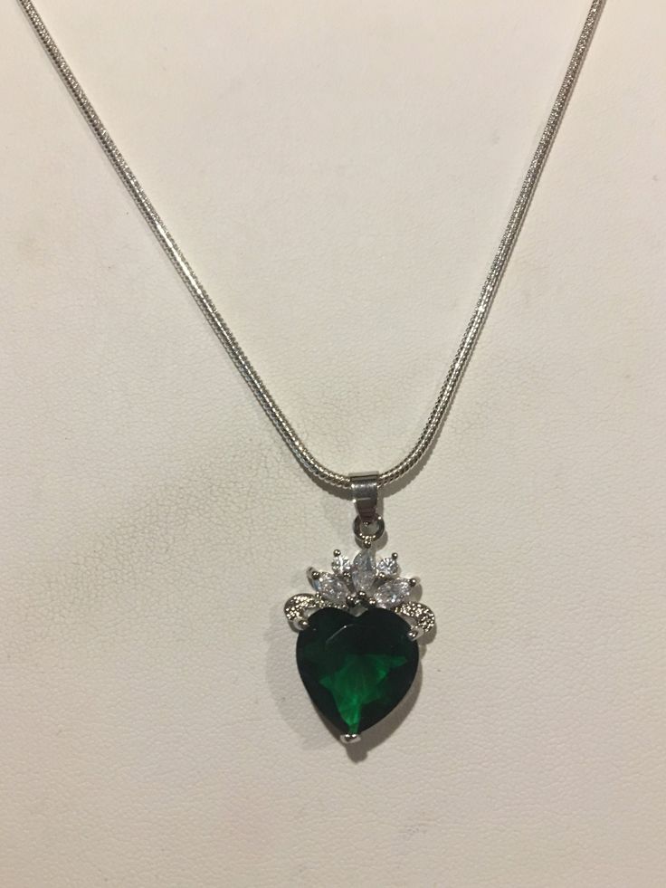 "Beautiful Emerald  and Crystal Heart shape Pendant is on an 18\"  Silver Necklace. The pendant is almost an inch tall and 1/2' wide. It is a beautiful gift to give someone or purchase for yourself ! Lab Created Please check through my other listings ! If you have any questions, feel free to ask as I do not accept returns ! Thank You for stopping by" Silver Heart Cut Necklace For May Birthstone, May Birthstone Heart Pendant Necklace, Green Heart Pendant Necklace For Mother's Day, Green Heart Necklace, Heart Shaped Pendant Necklace, Green Heart, Emerald Pendant, Necklace Crystal, Heart Shape Pendant