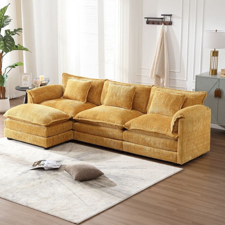 a yellow sectional sofa sitting on top of a white rug