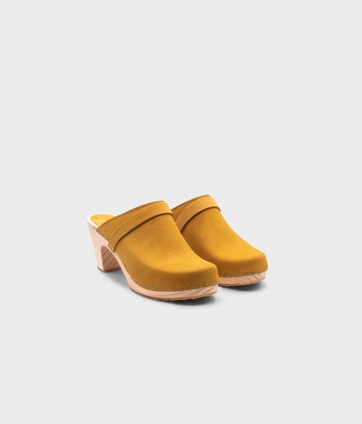 The Maya Clog Mules are the perfect blend of elegance and simplicity. These clogs for women boast a sleek design that exudes timeless sophistication. The high-heel silhouette is both feminine and professional, making them ideal for any occasion. Crafted with quality materials, these mules provide long-lasting comfort and durability without compromising on style. Clog measurements:Heel height: 3 1/8'' (8 cm)Toe height: 1 1/4'' (3.2 cm) Fit:NarrowLeather:Nubuck leatherClogs consist of:Base: Spanis Formal Slip-on Clogs With Reinforced Heel, Classic Mules With Sculpted Low Heel, Chic Slip-on Clogs With Reinforced Heel, Modern Slip-on Heels With Wooden Heel, Low Heel Mules With Wooden Heel For Workwear, Low Heel Wooden Mules For Work, Workwear Mules With Wooden Low Heel, Workwear Mules With Low Wooden Heel, Modern Clogs With Rubber Sole And Open Heel