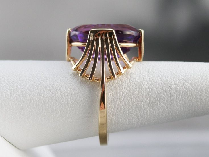 This stunning vintage Amethyst ring has a rich, bright purple Amethyst in the center that flashes and flickers with vibrant violet reflections! Set into a lovely vintage mounting with winged wire work, this ring makes a bold statement! Metal: 14K Yellow Gold Gem: Amethyst Gem Measurements: 12.5 x 16.8 mm, Oval Ring Size: 8.25 SKU #: 33488M70 Each piece has been identified and graded by a Graduate Gemologist who has been certified by the Gemological Institute of America (GIA). We have four brick Luxury Multi-stone Amethyst Ring In Yellow Gold, Antique Gold Amethyst Ring With Multi-stone, Luxury Gold Multi-stone Amethyst Ring, Elegant Multi-stone Amethyst Collectible Ring, Gold Amethyst Ring, Fine Jewelry Collectible, Yellow Gold Amethyst Ring, Yellow Gold Sapphire Ring, Amethyst Ring Vintage, Amethyst Cocktail Ring