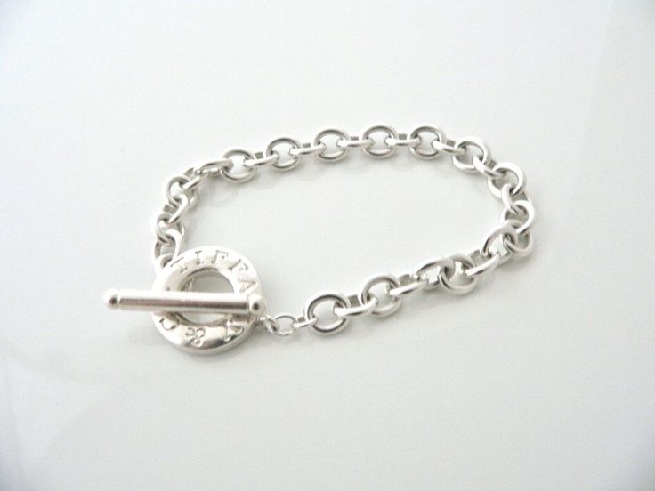 Offered for sale is a wonderful and gorgeous Tiffany & Co. Sterling Silver Toggle bracelet. Definitely a Tiffany piece that you will get your money's value for. It works perfectly with pretty much any attire your put on, AND is an awesome statement piece. Looks great worn alone, stacked with other bracelets, or you can add your own charms to personalize the piece! Classic Tiffany statement piece! It is the perfect necklace that fits a lifestyle on the go -- the piece can be worn to pretty mu Tiffany Bracelet Silver, Tiffany Bracelet, Tiffany Bracelets, 16th Birthday Gifts, Charm Chain, Gift Love, Toggle Bracelet, Silver Bangle Bracelets, Bracelet Bangle